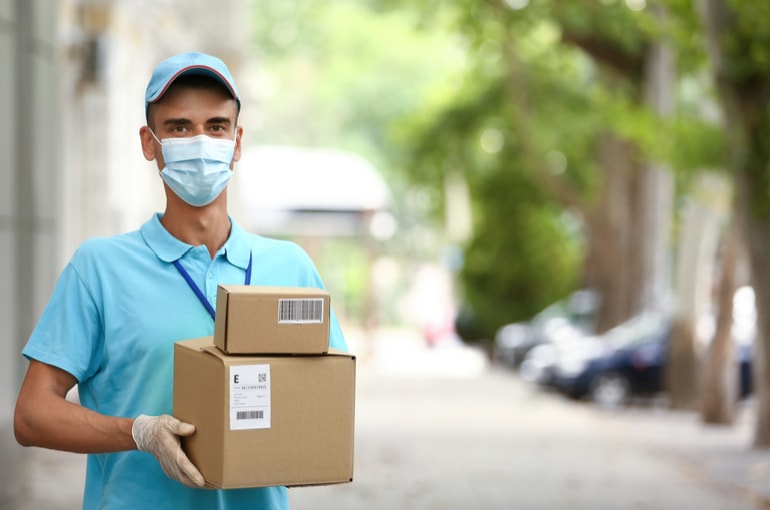 Ivy Logistics medical courier in mask and gloves carrying packages